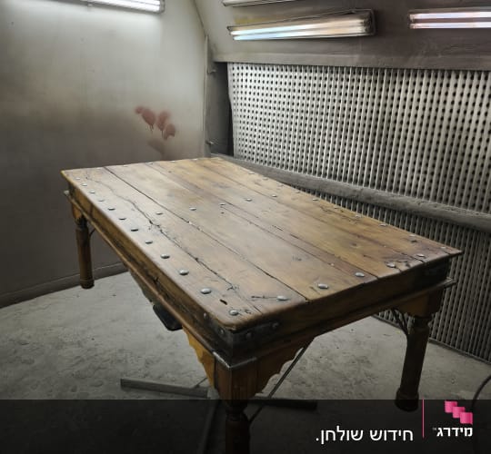 שולחן עץ עם מסמרים בחדר עבודה מואר